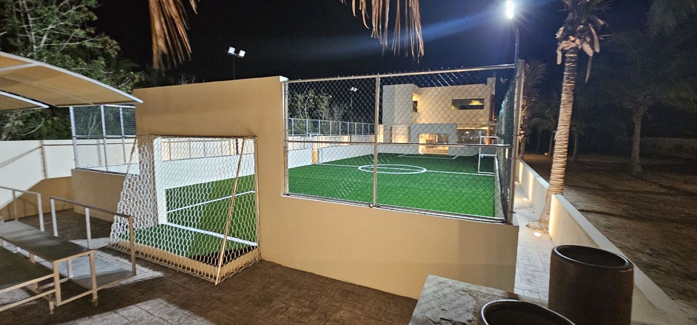 Porterías de fútbol rápido en cancha de pasto sintético iluminada de noche