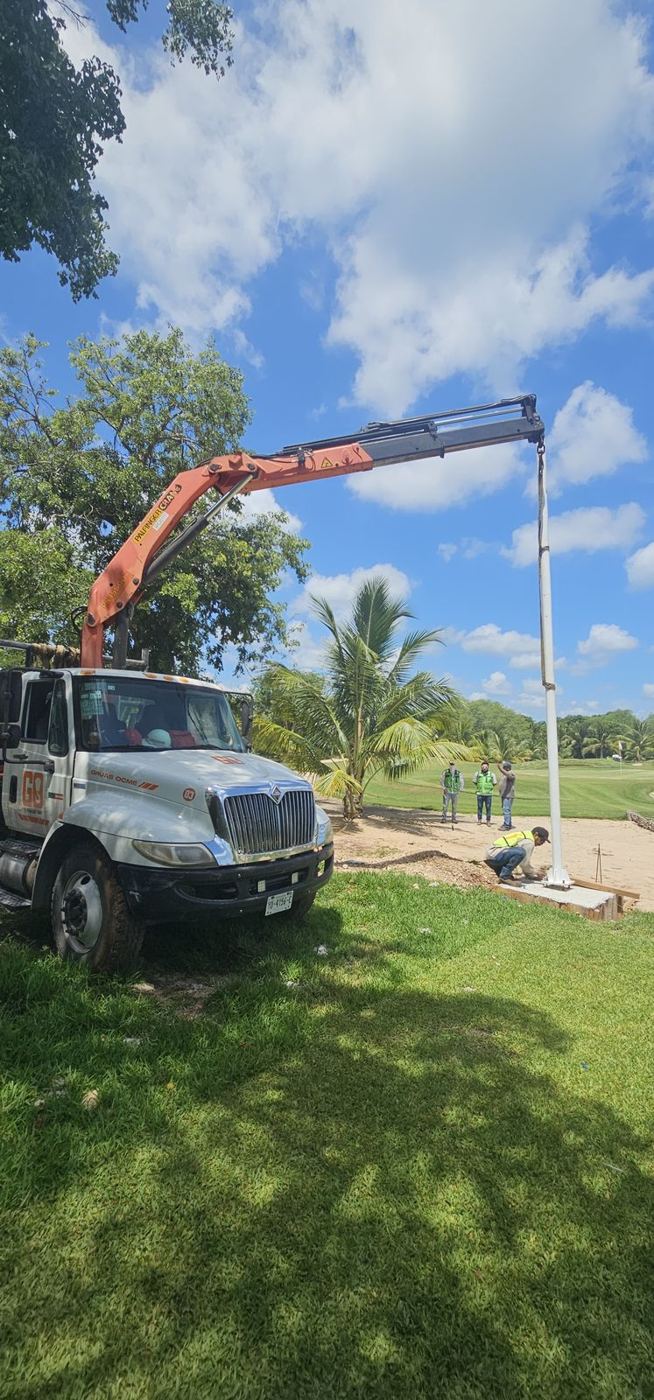 Camión grúa izando un poste para la instalación de una red perimetral