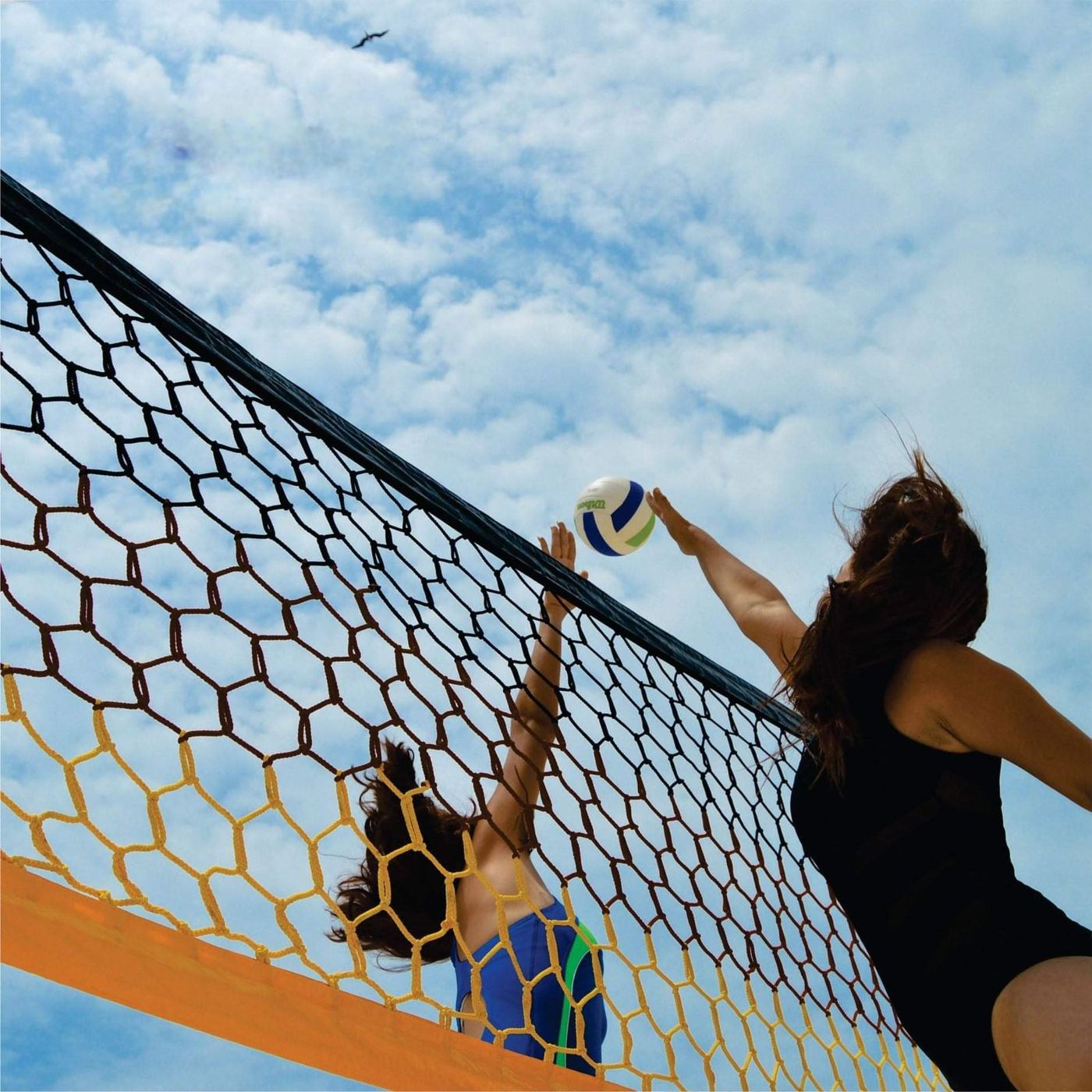 Jugadoras rematando sobre una red de voleibol de playa hexagonal de colores